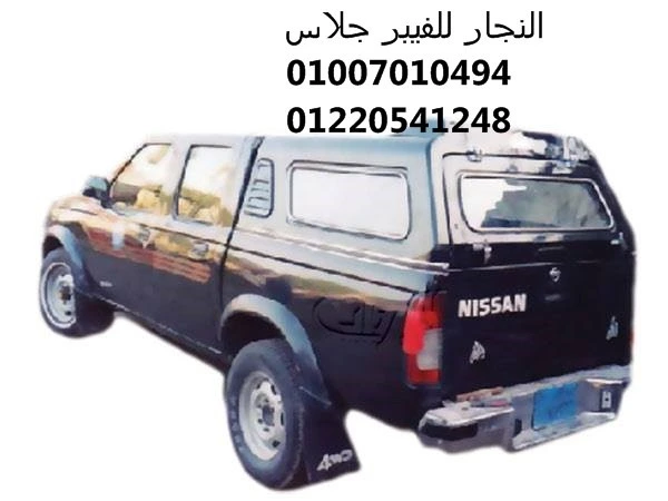 سيارة نيسان بيك أب سوداء مجهزة بكابينة فيبر جلاس (توبار) متينة لحماية الصندوق، تتميز بتصميم انسيابي مخصص للاستخدامات الشاقة وتجهيزات سيارات النقل التجارية في مصر.