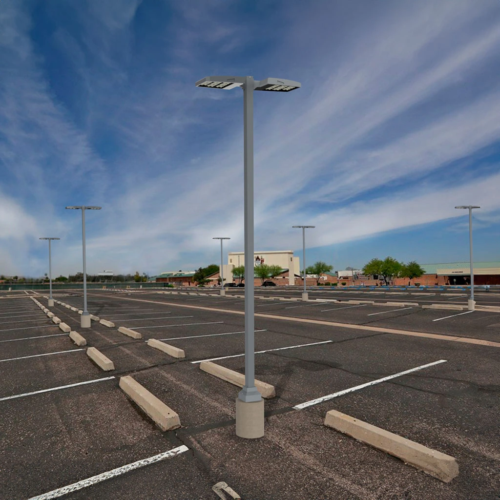 ساحة انتظار سيارات واسعة تضم أعمدة إنارة فيبر جلاس موزعة بانتظام تحت سماء زرقاء صافية، حيث تظهر خطوط التحديد البيضاء مع مساحات خضراء في الخلفية، مما يبرز دور أعمدة الإنارة الخارجية في تأمين وتجميل المناطق العامة.