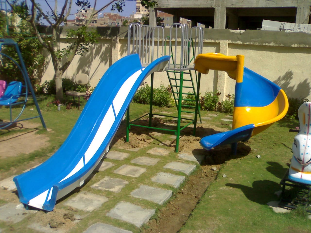 "مجمع ألعاب حدائق فيبر جلاس يضم زحليقة حلزونية صفراء وزحليقة موجية زرقاء مع منطقة مراجيح لتجهيز لاندسكيب الفلل والنوادي"