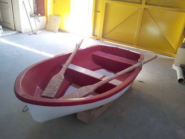 قارب تجديف صغير من الفيبر جلاس باللونين الأحمر والأبيض مع مجاديف خشبية، يتميز بمتانة عالية وتصميم كلاسيكي، مثالي للاستخدام في البحيرات الصناعية كجزء من ألعاب مائية فيبر جلاس ومنتزهات الترفيه.