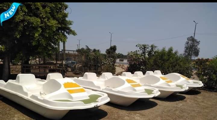 مجموعة من البدالات المائية (بدالات فيبر جلاس) باللون الأبيض مع تصاميم باللونين الأصفر والأخضر، مصطفة في منطقة انتظار، تمثل جزءاً من تجهيزات ألعاب مائية فيبر جلاس للمصايف والبحيرات والمنتزهات الترفيهية.