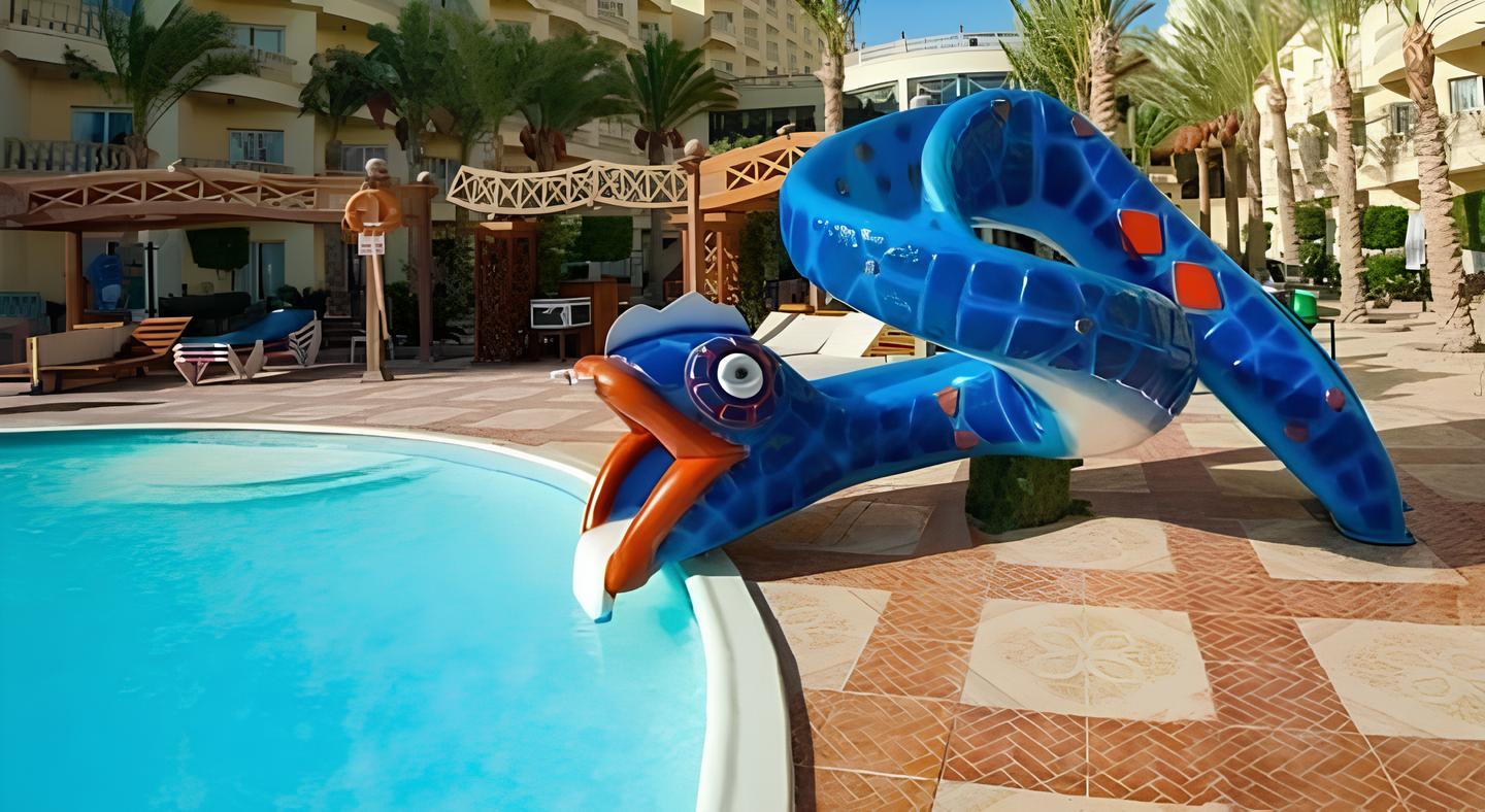 زحليقة مائية فيبر جلاس للأطفال بتصميم مرح على شكل ثعبان ملون بالأزرق والبرتقالي، منحنية داخل حمام سباحة صافٍ، مثالية لتجهيزات أكوا بارك فيبر جلاس في المنتجعات والفنادق السياحية.