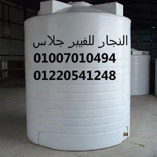 خزان مياه فيبر جلاس كبير الحجم باللون الأبيض في موقع صناعي واسع، مطبوع عليه بيانات التواصل والشركة باللغة العربية؛ يتميز بمتانة عالية وتصميم عملي لتخزين المياه والكيماويات، مصنع من خامات الفيبر جلاس المقاومة للتآكل والعوامل الجوية.