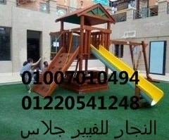 أطفال يستمتعون باللعب على مجموعة ألعاب خشبية خارجية مزودة بزحليقة فيبر جلاس ومنحدر تسلق على عشب صناعي، مصممة بمواد مقاومة للعوامل الجوية لتجهيز المدارس والحدائق في مصر.