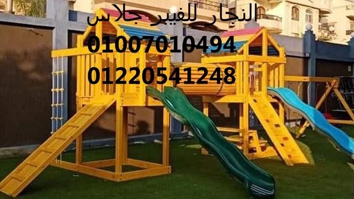 مجمع ألعاب خشبية للحدائق باللون الأصفر يضم زحاليق فيبر جلاس وهياكل تسلق متينة، مثبت على نجيل أخضر لتوفير منطقة ترفيهية آمنة للأطفال في المجمعات السكنية مع أرقام التواصل للتجهيزات.