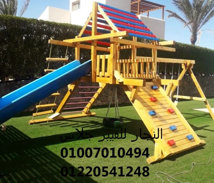 مجمع ألعاب خشبية ملون للحدائق يضم زحليقة فيبر جلاس زرقاء، جدار تسلق، وأراجيح مع منصة مغطاة، مصمم بأعلى معايير الأمان لضمان متعة الأطفال في المساحات الخضراء المفتوحة.