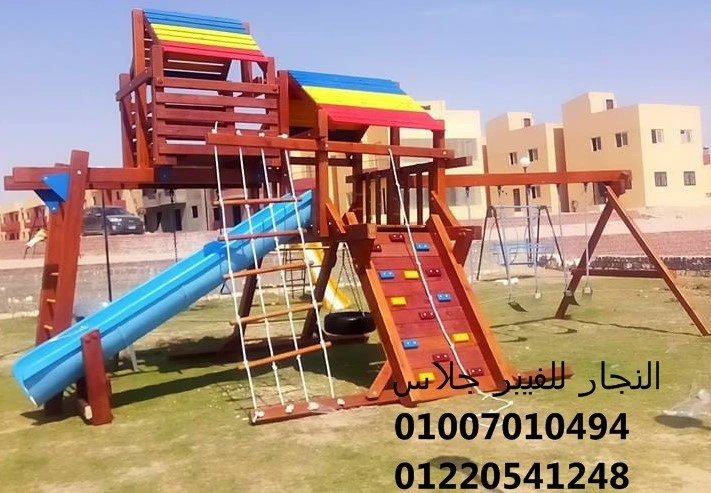 مجمع ألعاب خشبية ملون للحدائق يضم زحليقة فيبر جلاس زرقاء، جدار تسلق، أراجيح، وحبال متينة، مصمم بأعلى معايير الأمان لتجهيز مناطق ألعاب الأطفال في الفلل والمجمعات السكنية.